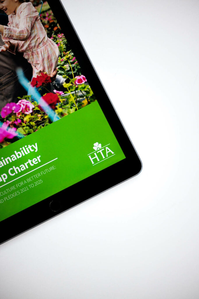 Close up of the edge of an iPad with a viid green footer that features the HTA logo.