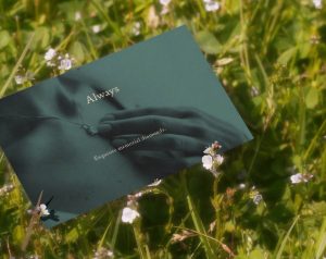 Close up of a green postcard featuring an image of a lady holding a diamond necklace. The headline reads "Always". This is a key part of EverAmour's brand refresh graphic design project.