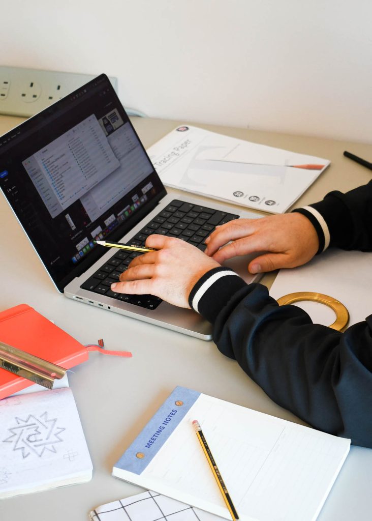 Graphic designer Dennis Cook works on a digital design project on his laptop in his laptop in a Devon design studio.
